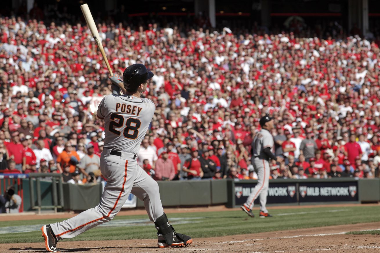 Giants’ Buster Posey watches his fifth inning grand slam sail over the wall, as the San Francisco Giants went on to beat the Cincinnati Reds 6-4 in game five to win the National League Division Series in Cincinnati, Ohio on Thursday Oct. 11, 2012.